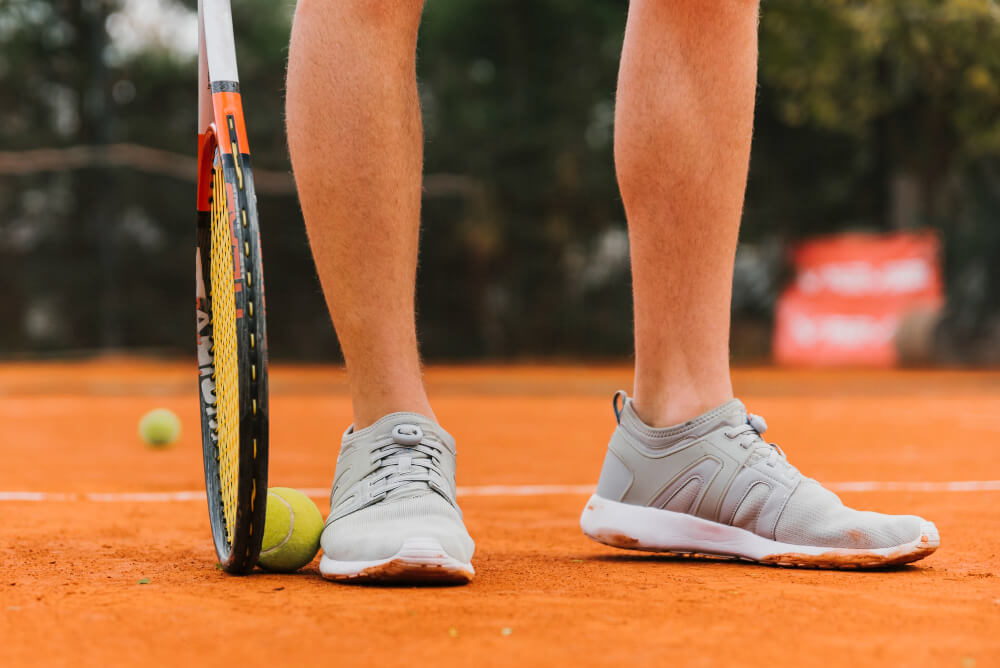 Panier rempli de balles de padel jaunes sur un court.